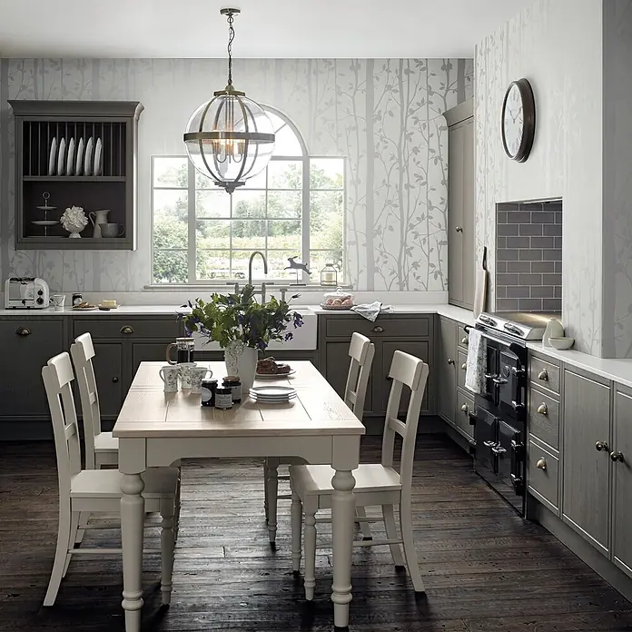 Laura Ashley Vliestapete Vliestapete Pappel Perlmutt - Weiß, Sonstiges, 10 x 0,52 m - Rustikale Küche mit grauen Schränken, hellem Holztisch, weißen Stühlen und gemusterter Tapete.