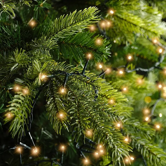 Lumineo Guirnalda luminosa LED a Batería - Para exterior, Blanco cálido tradicional, Número de bombillas: 160 ud., 4 m, Funciona con pilas - Guirnalda de luces LED blanco cálido entre ramas realistas de abeto artificial verde.