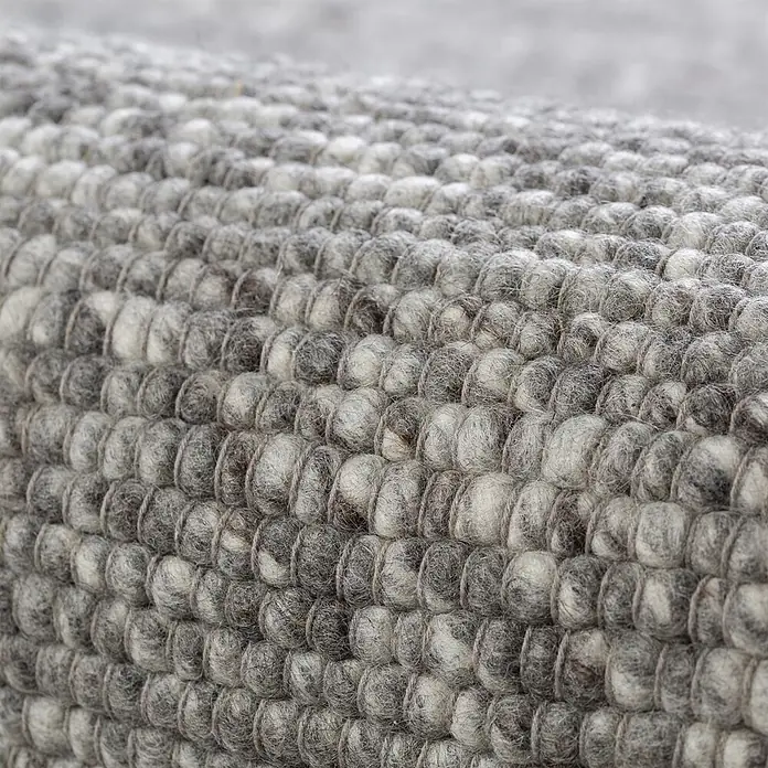 Kayoom Wollteppich Kvell 875 - Silber, 170 x 120 cm, 100 % Wolle - Strukturierter Teppich aus grau-weißem Filz mit Noppenmuster in Nahaufnahme.