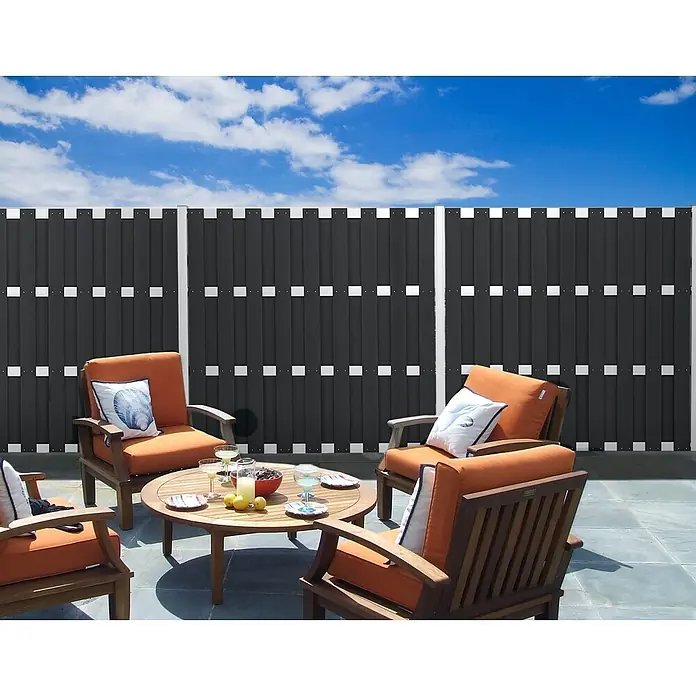 GartenLand WPC Bretterzaun Relax Anthrazit Alu Anthrazit Bausatz -  - Dunkelgrauer Sichtschutzzaun auf einer Terrasse, der Privatsphäre für Sitzgelegenheiten im Freien bietet.