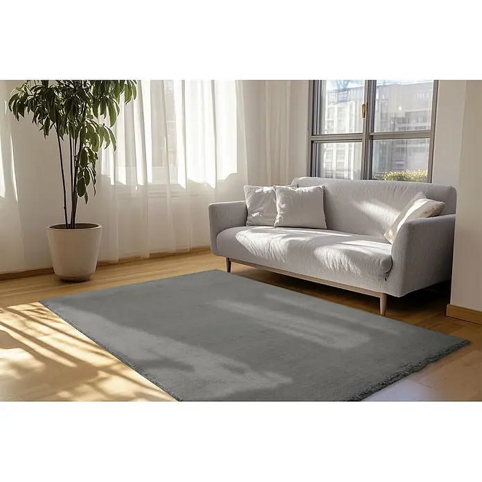 Kayoom Fellteppich Luxe 525 - Karbongrau, 230 x 160 cm, 90 % Polyester, 10 % Wolle - Grauer Teppich auf Holzboden in einem sonnigen Wohnzimmer.