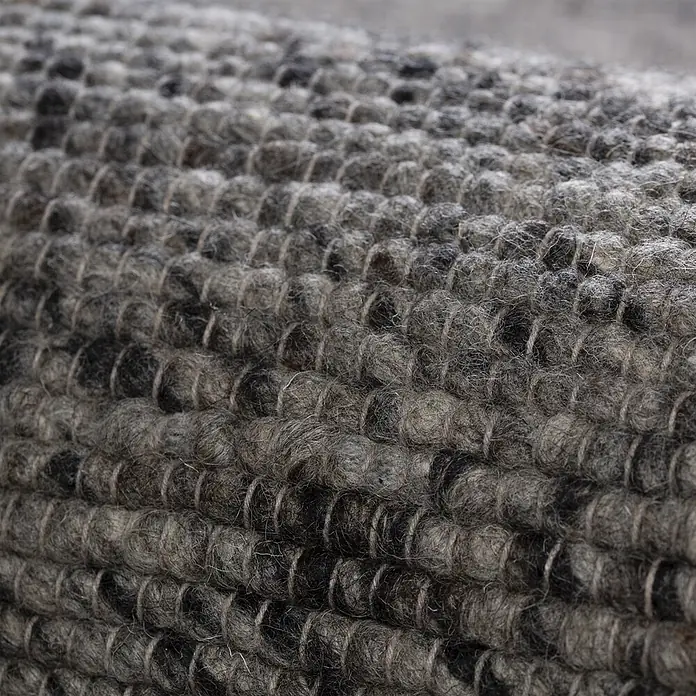 Kayoom Wollteppich Kvell 875 - Graphit, 200 x 140 cm, 100 % Wolle - Nahaufnahme eines grob gestrickten, melierten grau-schwarzen Filzwollteppichs.