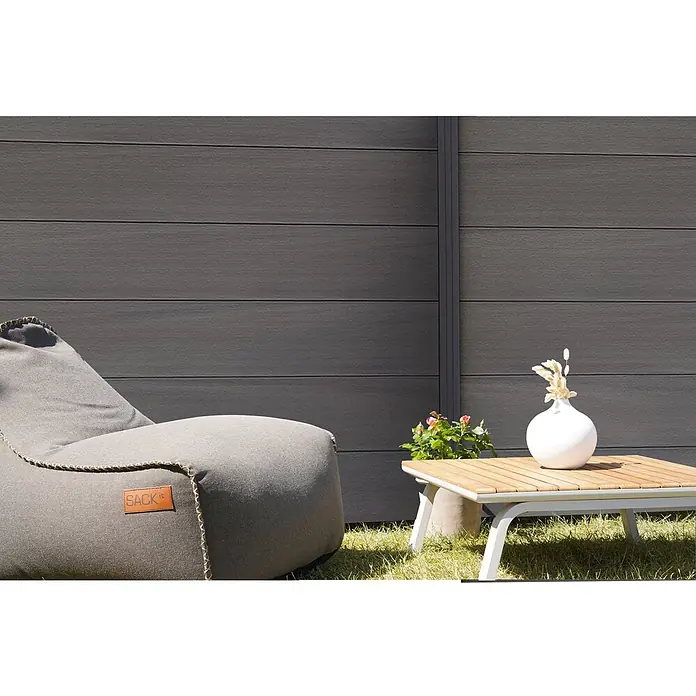 GartenLand Steckzaun-Element WPC Zaun Ameland Co-extrudiert Ohne Pfosten Ohne Abschlussleiste - B x H: 180 x 180 cm, Amethystgrau, Verbundwerkstoff - Grauer Sitzsack mit SACK it-Lederetikett auf Gras neben einem Holztisch.