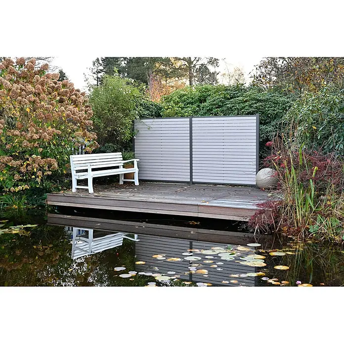 GartenLand Steckzaun-Element WPC Zaun Stockholm Musterstück - B x H: 20 x 7,5 cm, Sand-Multicolor, Verbundwerkstoff - Weiße Holzgartenbank und hellgrauer Sichtschutz auf einer Holzterrasse neben einem Teich, umgeben von Gartenpflanzen.