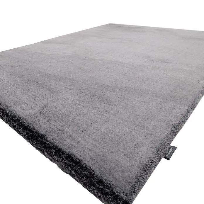 Kayoom Fellteppich Luxe 525 - Karbongrau, 230 x 160 cm, 90 % Polyester, 10 % Wolle - Plüschiger grauer Kunstfellteppich, der seine weiche Textur und dunklere Umrandung zeigt.