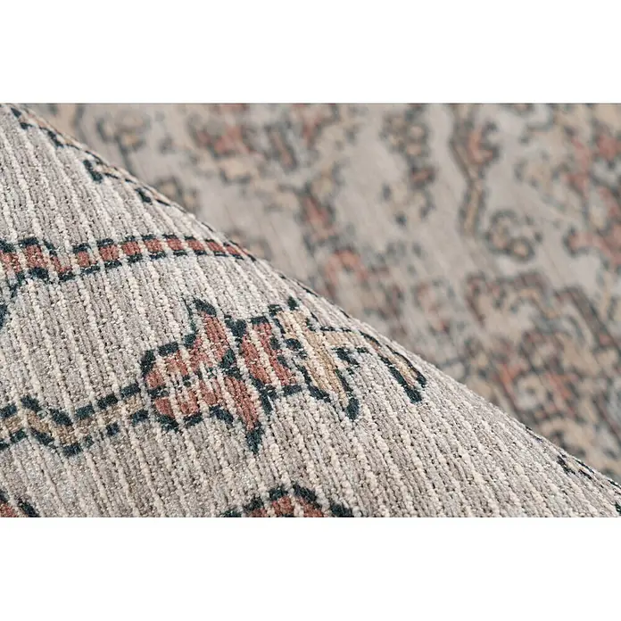 Kayoom Flachgewebeteppich Perry 325 - Beige, 170 x 120 cm, 75 % Baumwolle, 25 % Polyester - Nahaufnahme eines gemusterten Teppichs, teilweise gerollt, zeigt seine Webstruktur und abstraktes Design in Beige, Braun und Dunkeltürkis.