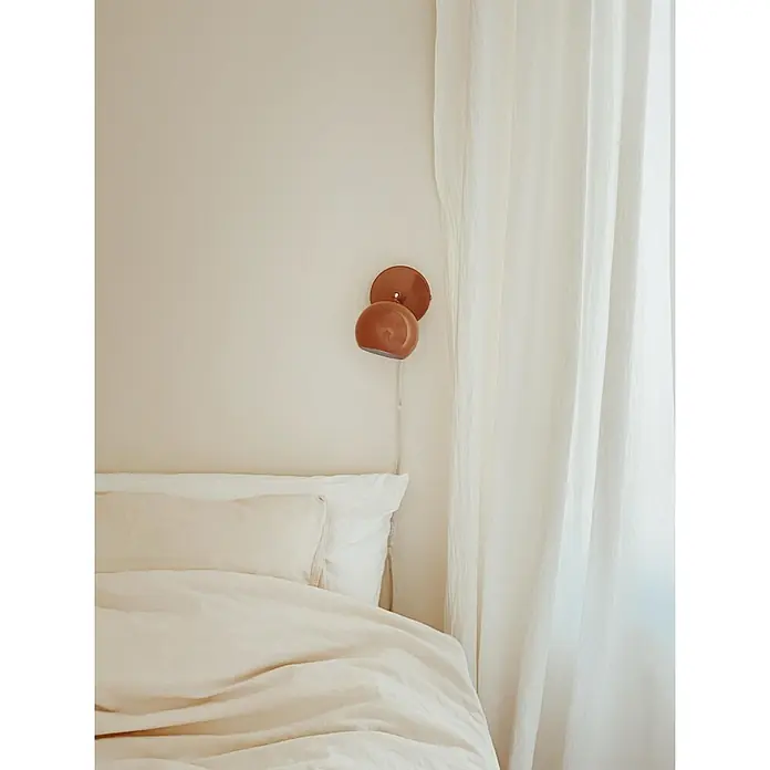 Markslöjd Wandleuchte - L x B x H: 18,5 x 10 x 14 cm, Braun, GU10 - Kupferbraune Wandleuchte mit rundem Schirm, über einem Bett neben einem weißen Vorhang montiert.