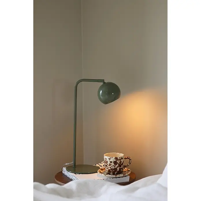 Markslöjd Tischleuchte - L x B x H: 25 x 15 x 39,5 cm, Grün, GU10 - Eine grüne Schreibtischlampe beleuchtet eine braun-weiß gesprenkelte Tasse mit Untertasse auf einem Nachttisch.