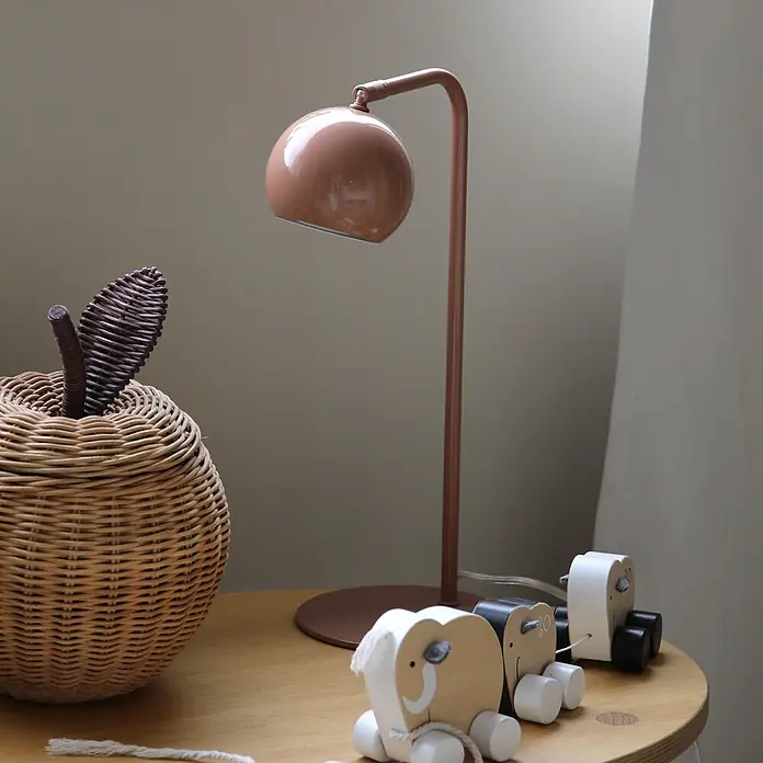 Markslöjd Tischleuchte - L x B x H: 25 x 15 x 39,5 cm, Braun, GU10 - Rosé goldene Tischlampe, geflochtener Apfelkorb und hölzerne Elefantenspielzeuge auf einem hellen Holztisch.