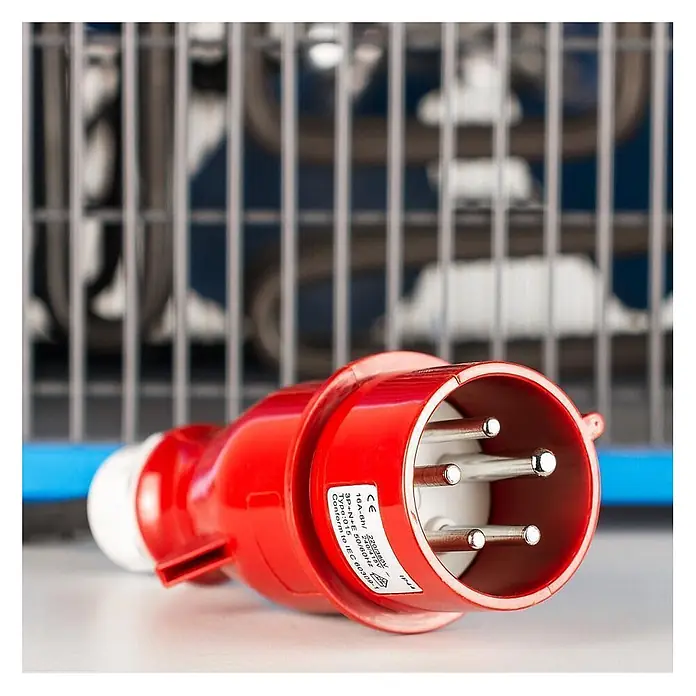 ALLEGRA Bauheizer AB-H92 - 9 kW, Nennspannung: 380 V - 400 V, Blau - Roter 5-poliger Industriestromstecker (CEE-Stecker) mit weißer Basis, vor Maschinen.