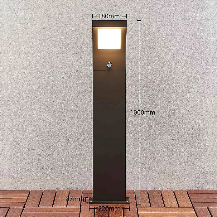 Arcchio Außenlaterne Advik -  - Dunkelgraue Metall-Pollerleuchte für außen, quadratisch, mit beleuchteter Oberseite und Sensor, 1000mm hoch, auf Holzterrasse.