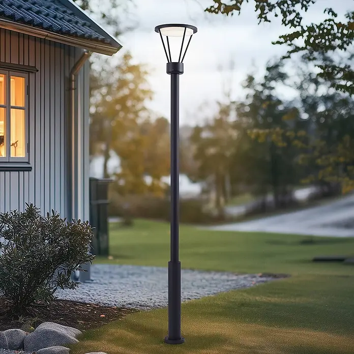 Lucande LED Gartenlaterne für draußen in schwarz matt, Mastleuchte -  - Schwarze Outdoor-Stehlampe beleuchtet einen Gartenweg neben einem Haus.