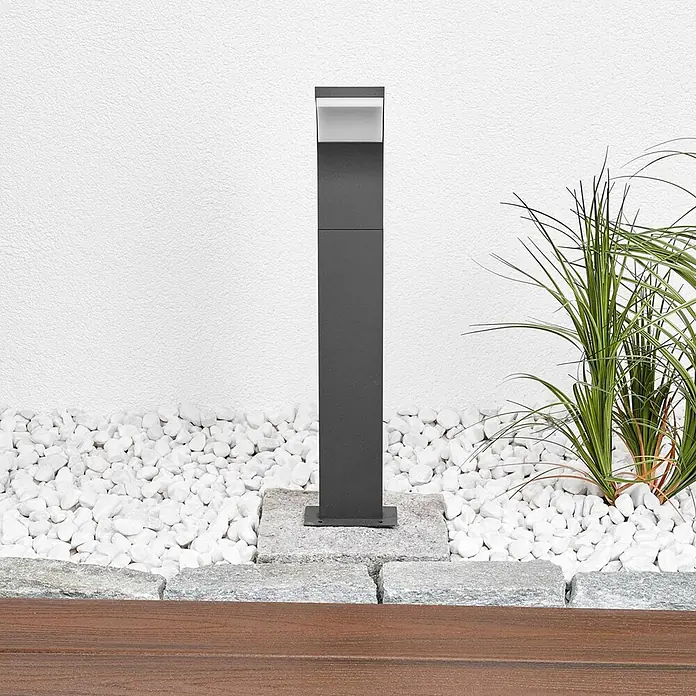 Lucande LED Wegeleuchte / Pollerleuchte, Höhe: 60 cm, inkl. 1x 5,8W LED -  - Dunkelgraue Außenwegleuchte in moderner Gartenanlage mit weißen Kieselsteinen und grünen Pflanzen.