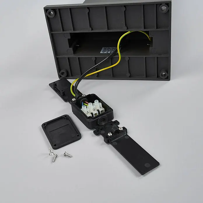 Arcchio Außenlaterne Yolena -  - Eine geöffnete schwarze elektrische Abzweigdose zeigt Kabelanschlüsse (N, Erde, L Klemmen) an eine Leuchtenbasis, Deckel und Schrauben sind abgenommen.