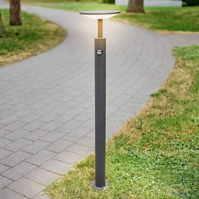 Lucande LED Wegeleuchte mit Bewegungsmelder Gartenleuchten mit Strom 100cm -  - Anthrazitfarbene Pollerleuchte mit Bewegungssensor, beleuchtet einen gepflasterten Gartenweg.