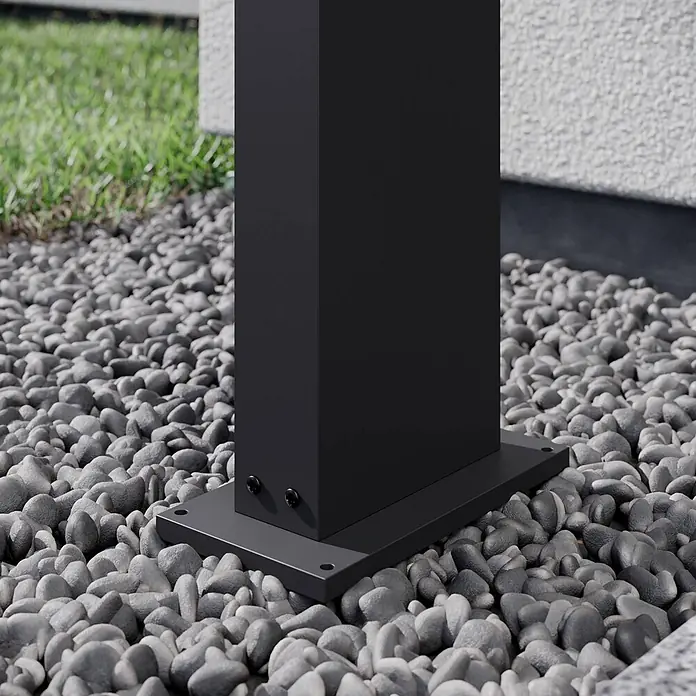 Arcchio LED Wegeleuchte in dunkelgrau, weiß, Gartenlampe -  - Schwarzer Metallpfostenfuß mit sichtbaren Schrauben, auf grauen Kieseln neben Gras installiert.