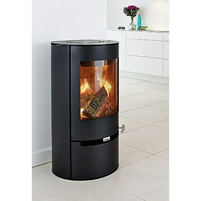 Aduro Kaminofen 9-1 - 8 kW, Raumheizvermögen: 334 m³, Material Verkleidung: Stahl, Schwarz - Ein moderner, schwarzer Kaminofen mit einem lebendigen Feuer, der in einem hellen Raum steht und Wärme und Stil vereint.