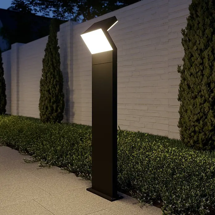 Arcchio LED Wegeleuchte in dunkelgrau, Gartenlampe -  - Moderne schwarze Gartenleuchte beleuchtet nachts einen gepflasterten Weg und Garten.