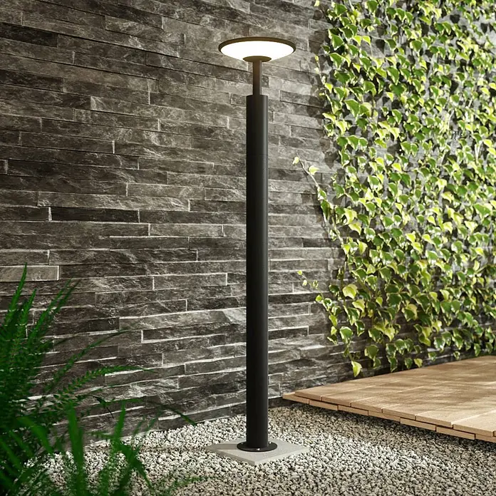 Lucande LED Wegeleuchte anthrazit Gartenlampe 100cm Pollerleuchte Aluminium -  - Schwarze Außen-Standleuchte mit weißem Licht, auf einem Kiesweg stehend.