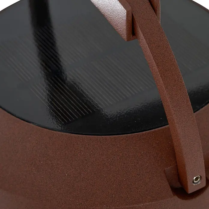 Lucande LED Solar Wandleuchte aussen in rost, weiß, dimmbar Aussenlampe -  - Nahaufnahme eines schwarzen Solarpanels, das in eine texturierte, dunkelbraune Vorrichtung mit Griff integriert ist, was auf ein solarbetriebenes Gerät hindeutet.