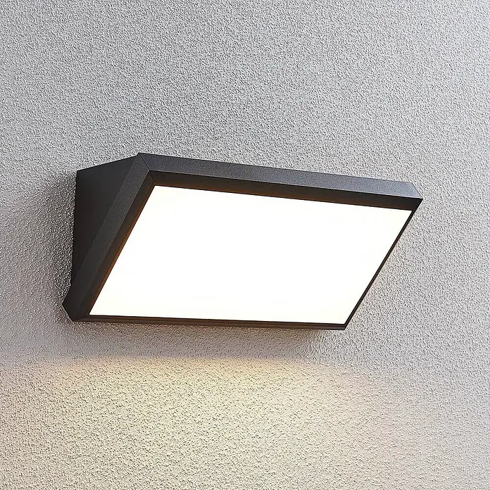 Lindby LED Wandleuchte aussen in dunkelgrau, weiß, Aussenlampe Wand -  - Dunkelgraue, eckige Außenwandleuchte beleuchtet eine strukturierte Wand darunter.
