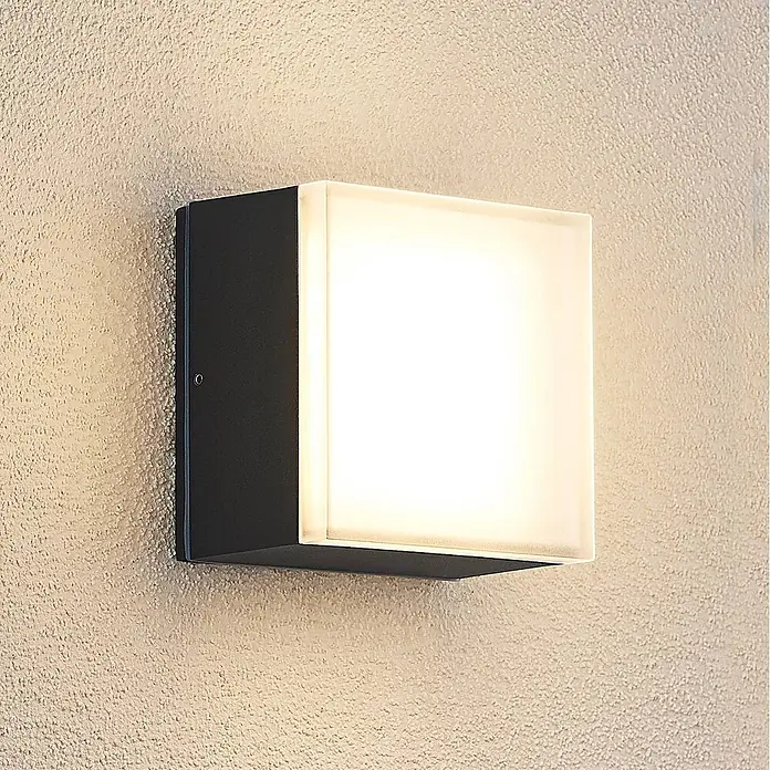Lindby LED Wandleuchte aussen in dunkelgrau, Aussenlampe Wand -  - Quadratische Außenwandleuchte mit dunklem Rahmen und leuchtendem Diffusor, an strukturierter Wand montiert.