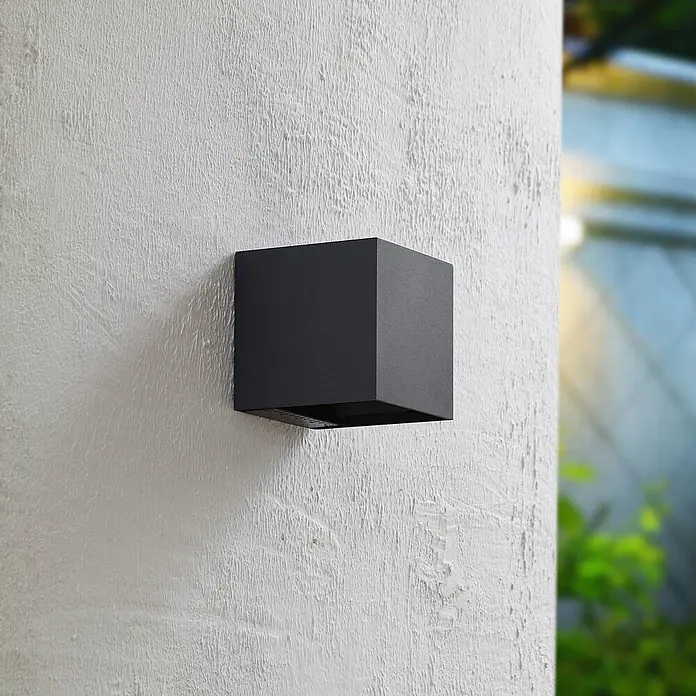 PRIOS LED Solar Wandleuchte aussen in anthrazit, mit Bewegungsmelder, -  - Dunkelgraue, würfelförmige Außenwandleuchte an einer strukturierten Außenwand montiert.