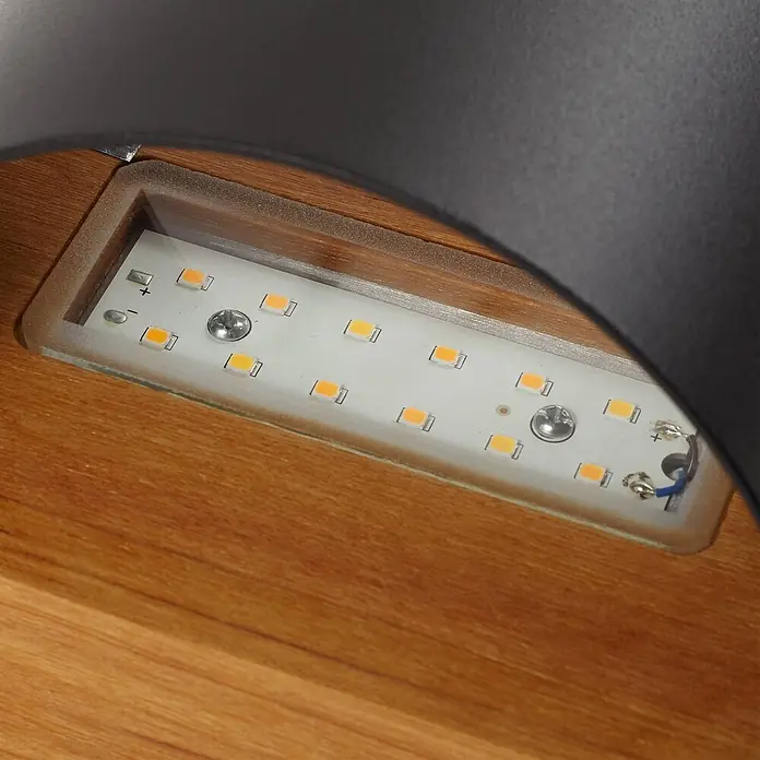 Lindby LED Wandleuchte aussen in schwarz, holz, up down Aussenlampe Wand -  - LED-Streifen mit orange-gelben Lichtern, in eine Holzvertiefung montiert, zeigt Plus- und Minuszeichen.