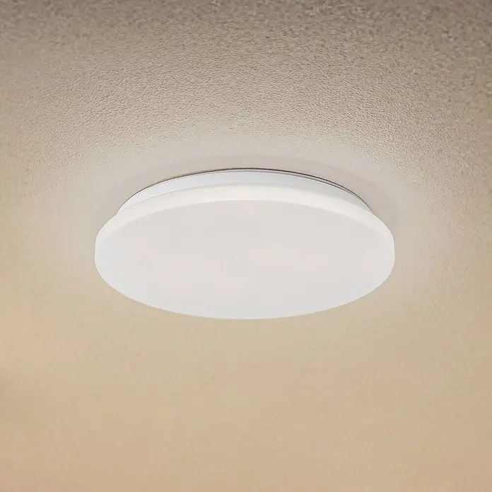 Lindby LED Outdoor Deckenlampe in weiß, mit Bewegungsmelder, Deckenleuchte -  - Weiße, runde flache LED-Deckenleuchte an einer strukturierten, hellen Decke.