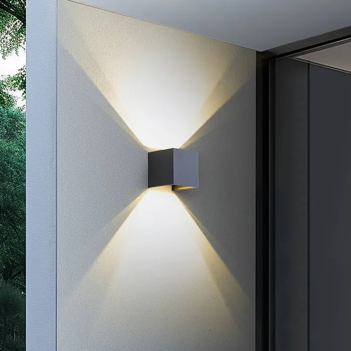 Lindby LED Wandleuchte aussen Smart Home in dunkelgrau, dimmbar up down -  - Dunkelgraue Kubus-Wandleuchte, spendet warmes Licht nach oben und unten an einer strukturierten Wand.