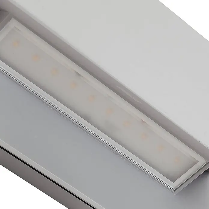 Lucande Außenwandleuchte Meja - alu / grau / zink, IP54 - Silberne lineare LED-Lichtschiene mit mattiertem Diffusor, die warmweiße LEDs zeigt.