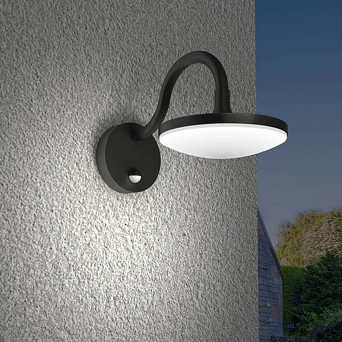 Lucande LED Wandleuchte aussen in dunkelgrau, weiß, mit Bewegungsmelder, -  - Schwarze Außenwandleuchte mit weißem Diffusor und Bewegungssensor, beleuchtet eine strukturierte Wand in der Dämmerung.