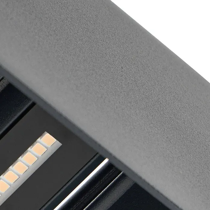 Lindby LED Wandleuchte aussen in anthrazit, Aussenlampe Wand -  - Nahaufnahme einer weißen LED-Lichtleiste mit rechteckigen Emittern, eingebettet in eine dunkelgraue, strukturierte Metallleuchte.