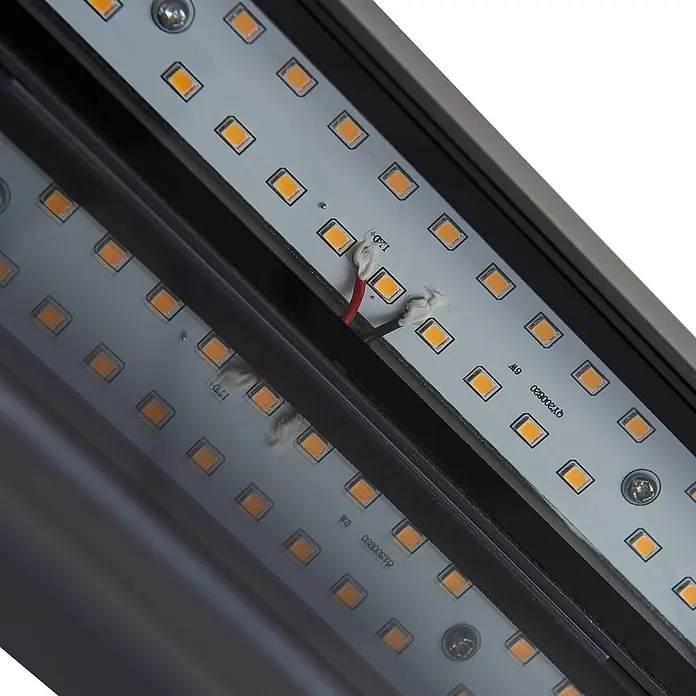 Lindby LED Wandleuchte aussen in dunkelgrau, Aussenlampe Wand -  - Nahaufnahme von zwei parallelen LED-Streifen mit orangefarbenen Lichtern, Verkabelung und dunkelgrauem Gehäuse.