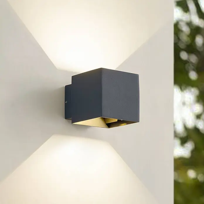 Lindby LED Wandleuchte aussen in anthrazit, Aussenlampe Wand -  - Dunkelgraue kubische Wandleuchte mit goldener Innenseite, die warmes Licht nach oben und unten an die Wand strahlt.