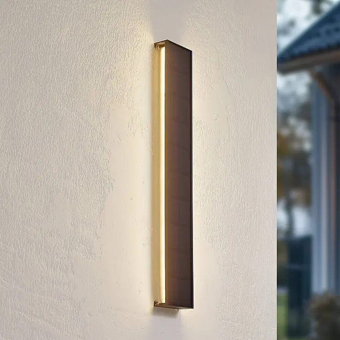 Lindby LED Solar Wandleuchte aussen in schwarz, weiß, dimmbar Aussenlampe -  - Moderne dunkle rechteckige Außenwandleuchte mit Leuchtstreifen an strukturierter Wand.