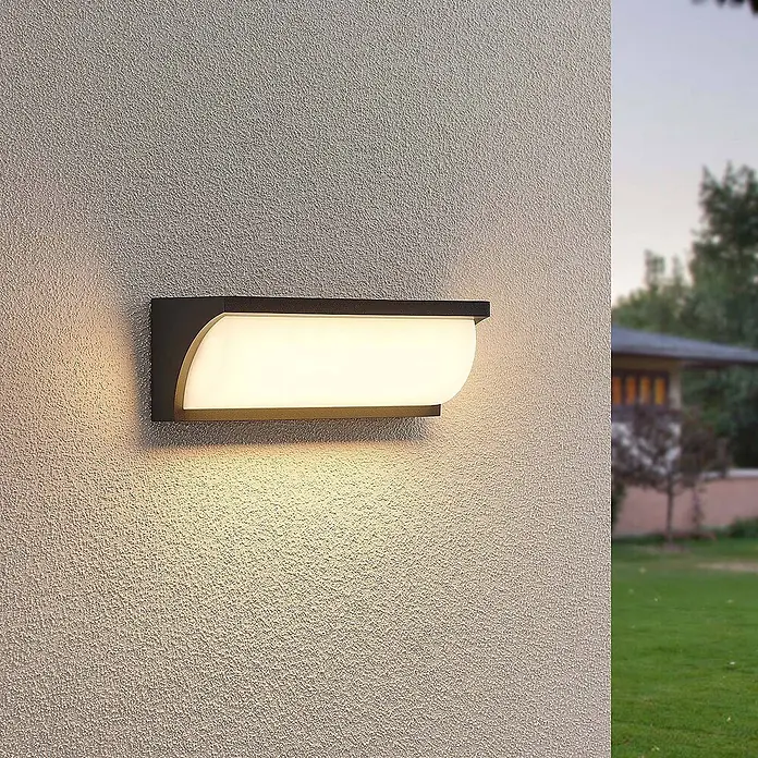 Lucande LED Wandleuchte aussen in anthrazit, weiß satiniert, Aussenlampe -  - Schwarze Außenwandleuchte mit mattweißem Diffusor an einer strukturierten Wand, die warmes Licht abstrahlt.