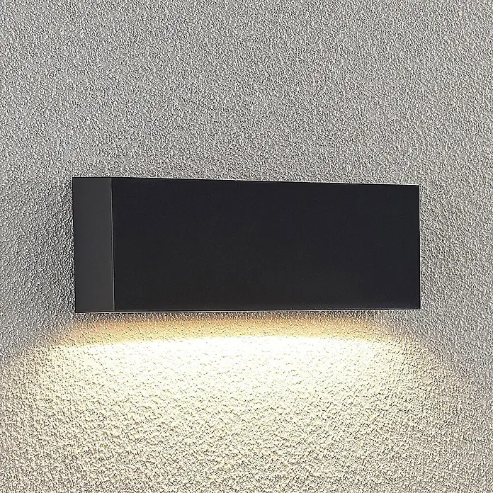 Lindby LED Wandleuchte aussen in dunkelgrau, Aussenlampe Wand -  - Schwarze rechteckige Wandleuchte mit warmer Abwärtsbeleuchtung auf einer strukturierten Wand.