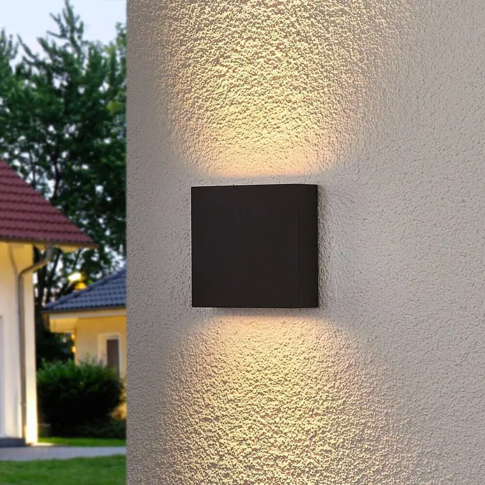 Lucande LED Wandleuchte aussen in anthrazit, transparent, Aussenlampe Wand -  - Schwarze rechteckige Außenwandleuchte, die warmes Licht nach oben und unten an einer strukturierten Außenwand abgibt.