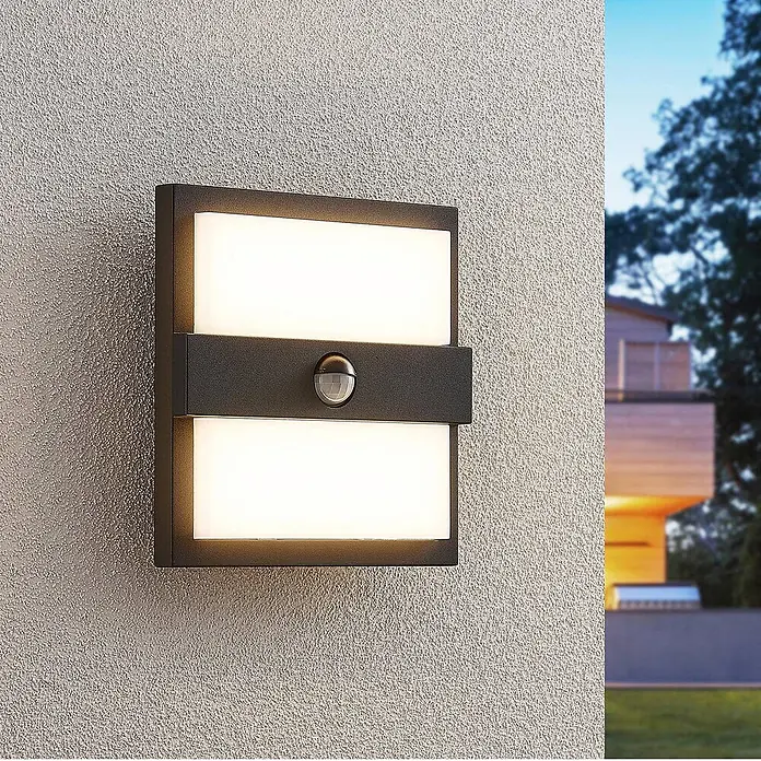 Lucande LED Wandleuchte aussen in anthrazit, weiß, mit Bewegungsmelder, -  - Anthrazitfarbene Außenwandleuchte mit weißen Leuchtflächen und integriertem Bewegungsmelder, an einer strukturierten Wand montiert.