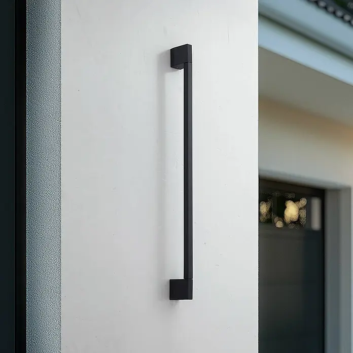 Lindby LED Wandleuchte aussen in schwarz, Aussenlampe Wand -  - Ein langer, schwarzer, quadratischer Stangengriff vertikal an einer hellen Wand montiert, möglicherweise für eine Tür oder einen Schrank.
