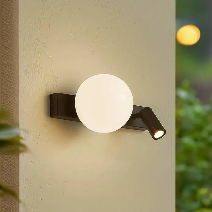 Lindby LED Wandleuchte aussen in schwarz, weiß, mit Bewegungsmelder, -  - Dunkelbraune Außenwandleuchte mit kugelförmigem, milchweißem Diffusor und verstellbarem Strahler an einer strukturierten Wand.