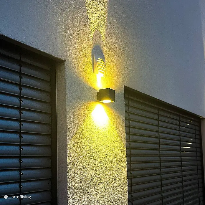 Lucande LED Wandleuchte aussen in graphit, up down Aussenlampe Wand -  - Kubische und dekorative Wandleuchten werfen warmes Licht nach oben und unten auf eine texturierte Außenwand.