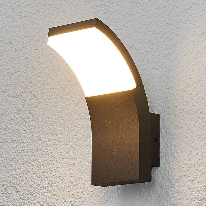 Lucande LED Wandleuchte aussen in anthrazit, weiß, Aussenlampe Wand -  - Geschwungene dunkelgraue Wandleuchte mit hellem, weißem Licht an einer strukturierten Wand.
