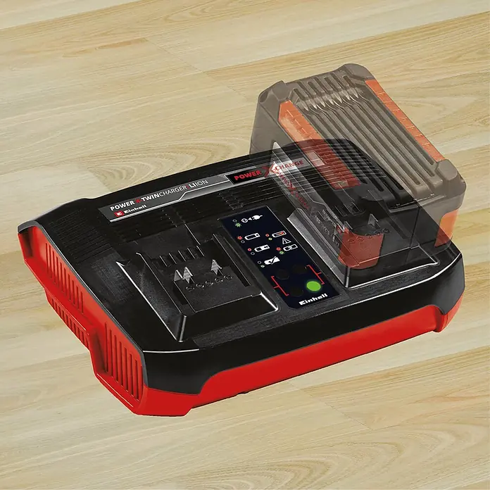 Einhell PXC 18V Cargador de pilas recargables Twincharger 3A - Específico para: Baterías Einhell Power X-Change - Cargador doble Einhell Power X-Change rojo y negro para baterías de iones de litio en suelo de madera, con una batería parcialmente insertada.