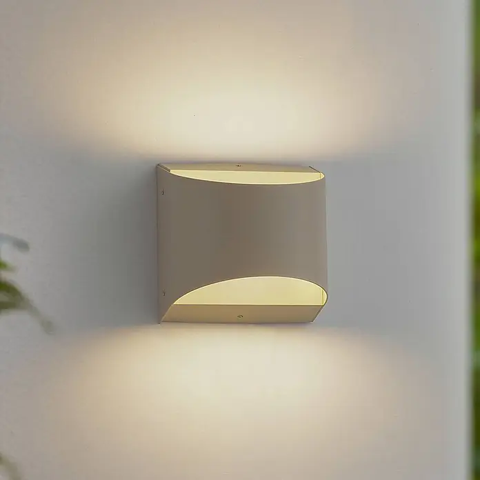Lindby LED Wandleuchte aussen in beige, up down Aussenlampe Wand -  - Beige Metall-Wandleuchte, die warmes Licht nach oben und unten auf eine strukturierte Wand wirft.