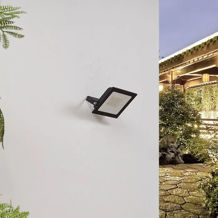 PRIOS LED Wandleuchte innen in schwarz, Wandstrahler -  - Schwarzer LED-Fluter an einer weißen Wand montiert, der einen Außenbereich mit Pergola beleuchtet.