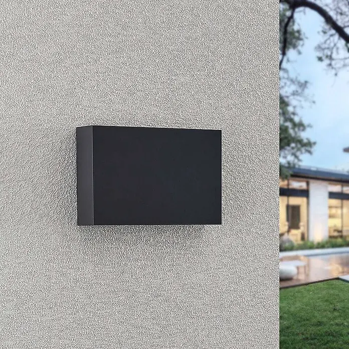 Lindby LED Wandleuchte aussen in dunkelgrau, up down Aussenlampe Wand -  - Schwarze rechteckige Außenwandleuchte an einer strukturierten Wand, beleuchtet das Äußere eines modernen Hauses.