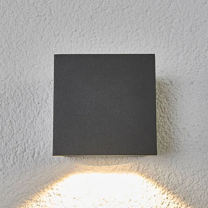 Lucande LED Wandleuchte aussen in dunkelgrau, Aussenlampe Wand -  - Dunkelgraue quadratische Wandleuchte an strukturierter Wand, wirft warmes Licht nach unten.