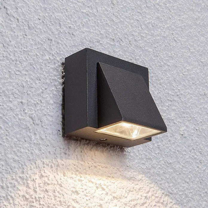 Lucande Außenwandleuchte Marik - schwarz, schwarz, IP54 - Dunkelgraue quadratische Außenwandleuchte, nach unten gerichtet auf eine strukturierte weiße Wand.
